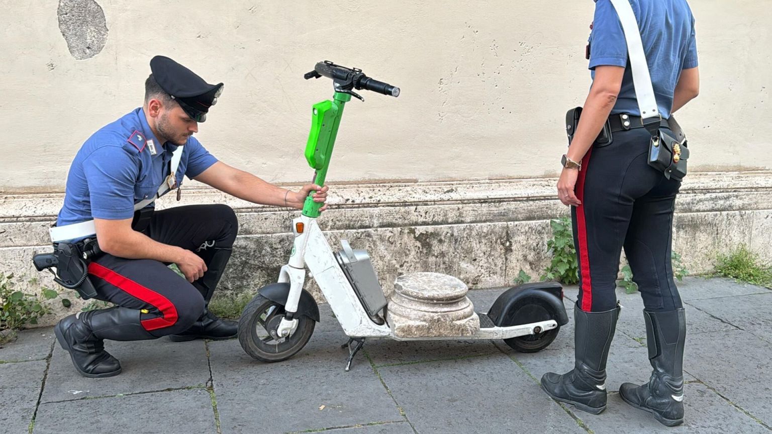 Deux carabiniers avec l'objet récupéré sur un scooter, à Rome, le 21 mai 2025.