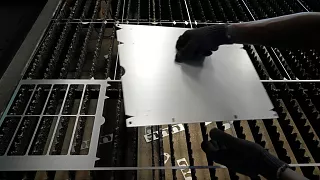 Un ouvrier soulève une tôle d'acier après l'avoir découpée selon un dessin spécifique dans une usine de la banlieue de Bengaluru, en Inde.